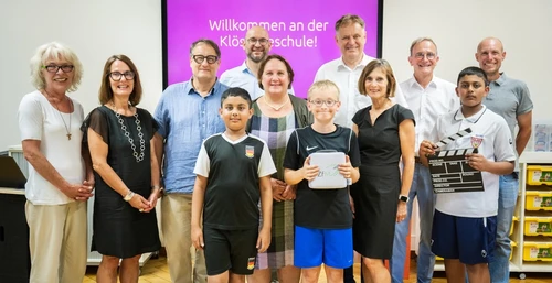 Martina Häußler (MDL, Grüne), Cathrin Michael-Koser (Staatl. Schulamt Göppingen), Prof. Dr. Thomas Irion (PH Gmünd), Prof. Dr. Kim-Patrick Sabla-Dimitrov (PH Gmünd), Kultusministerin Theresia Schopper, OB Richard Arnold, Schulleiterin Margrit Carbon, Jürgen Henzler (Staatl. Schulamt Göppingen), Stellv. Schulleitung Rajko Rost mit Schülern der Klösterleschule. Bildquelle: Rainer Teichmann.